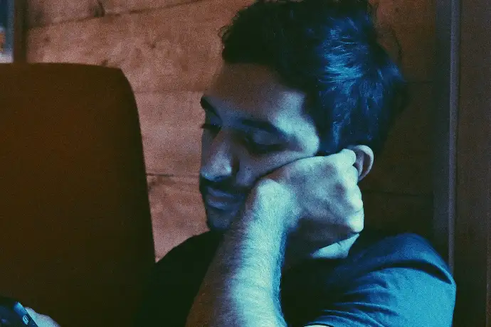 man leaning his face on his left hand
